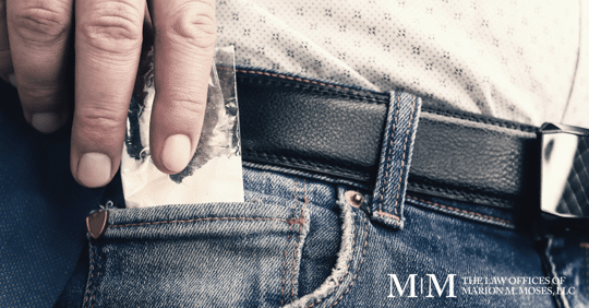 man slipping cocaine into his pocket